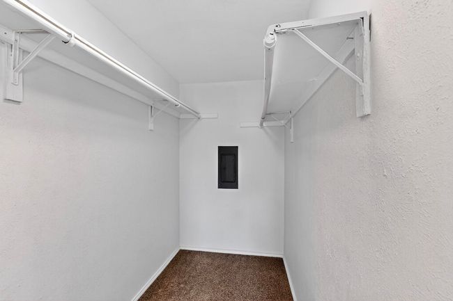 Walk in closet featuring electric panel and carpet floors | Image 26