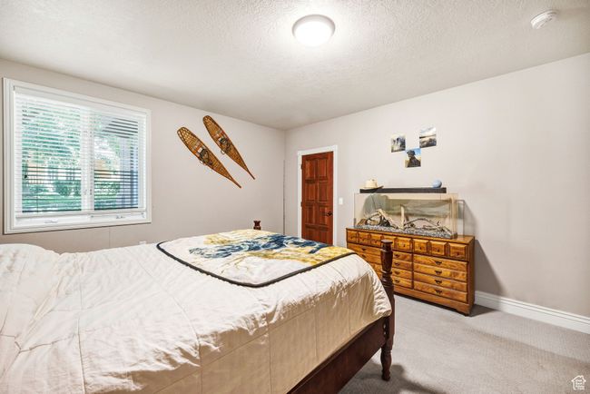 Carpeted bedroom with a textured ceiling and baseboards | Image 50