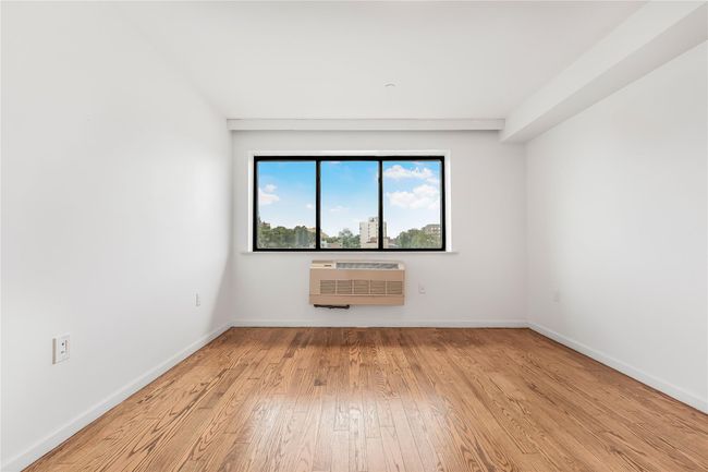Spare room featuring wood finished floors and an AC wall unit | Image 28