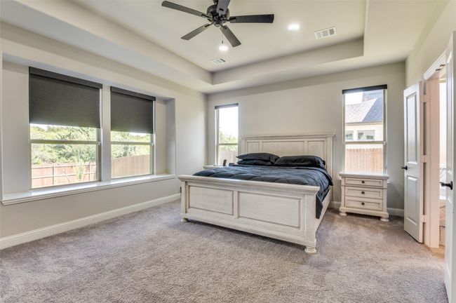 Bedroom with light colored carpet, a raised ceiling, recessed lighting, and ceiling fan | Image 24