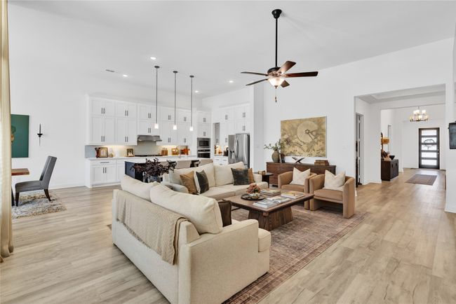 Living room featuring a chandelier, light wood-style flooring, a ceiling fan, and recessed lighting | Image 11
