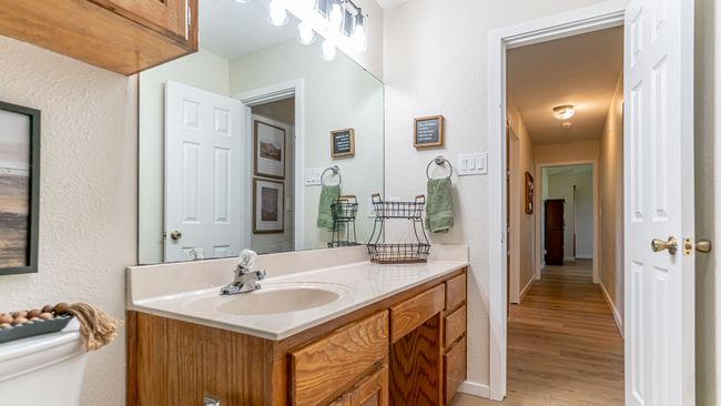 Bathroom with vanity, toilet, wood finished floors, a textured wall, and baseboards | Image 22