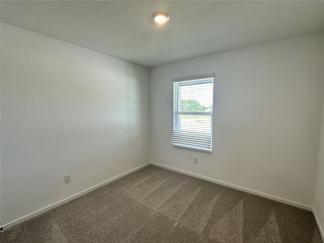 Spare room featuring dark carpet and baseboards | Image 12