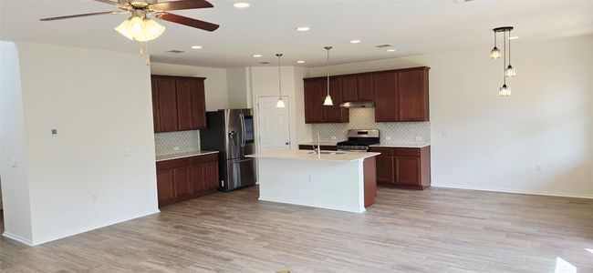 Kitchen featuring appliances with stainless steel finishes, under cabinet range hood, ceiling fan, tasteful backsplash, and recessed lighting | Image 10