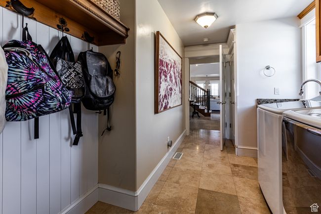 Hallway featuring light tile patterned flooring, stairway, baseboards, independent washer and dryer, and visible vents | Image 28