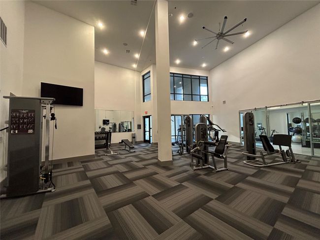 Exercise room with dark carpet and a high ceiling | Image 24