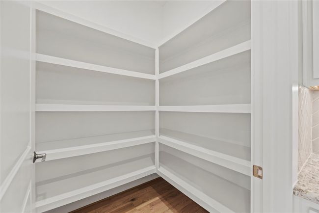The walk-in pantry offers plenty of room for food storage, small appliances, and bulk items keeping your kitchen clutter-free and everything you need easily accessible. With built-in shelving from wall to wall, organization has never been easier. | Image 20