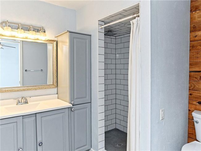 Bathroom with a stall shower, vanity, and a ceiling fan | Image 26