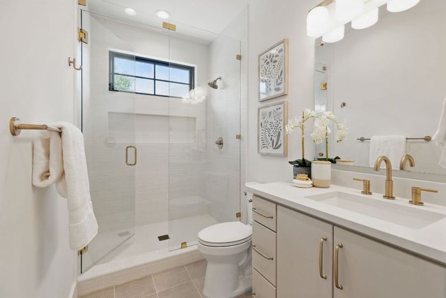 Bathroom with a stall shower, toilet, tile patterned floors, and vanity | Image 21