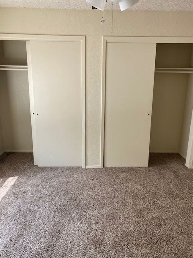 Unfurnished bedroom with carpet flooring, a closet, and ceiling fan | Image 9