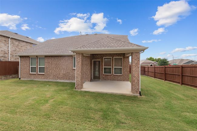 Rear view of house featuring a fenced backyard, a patio, a shingled roof, and brick siding | Image 35