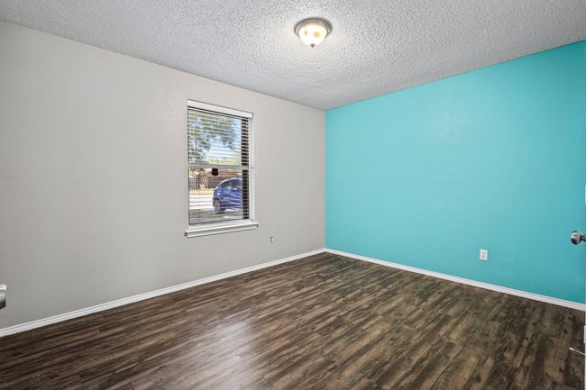 Empty room featuring wood finished floors, a textured ceiling, and baseboards | Image 17