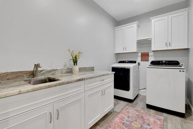 Spacious laundry with sink and folding area. | Image 35