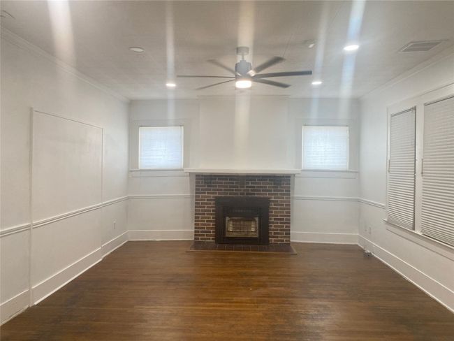 Front room with a ceiling fan, hardwood / wood-style flooring, a brick fireplace, ornamental molding, and recessed lighting | Image 12