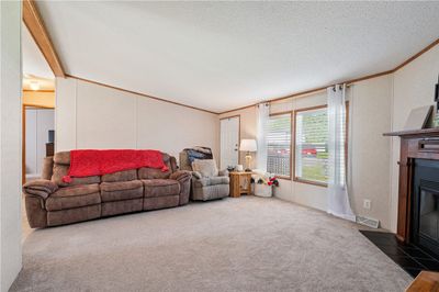 Spacious living room boasts oversized windows that flood the space with natural light...with ample room for seating and entertaining this space serves as the heart of the home...where family and friends come together. | Image 3