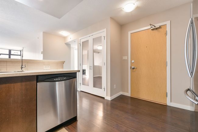 Kitchen with stainless steel appliances, light countertops, backsplash, and dark wood-type flooring | Image 13