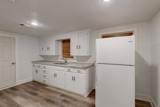 Kitchen featuring sink, a textured ceiling, white cabinets, and white refrigerator | Image 14
