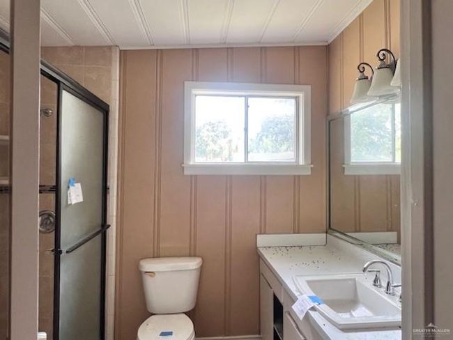 Full bathroom featuring a decorative wall, vanity, healthy amount of natural light, a shower stall, and crown molding | Image 15