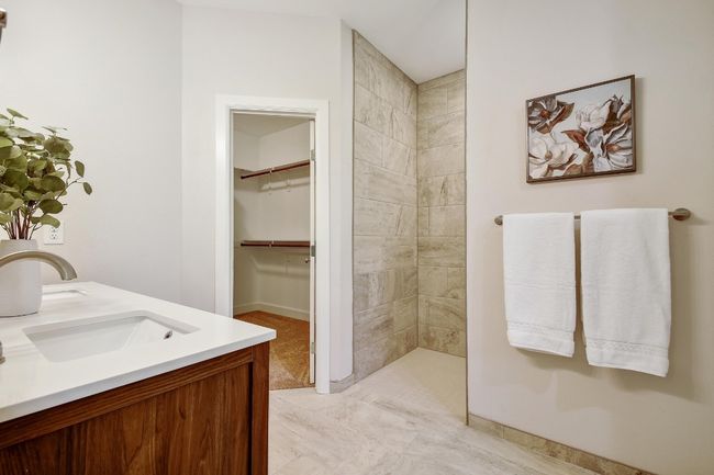 Full bathroom featuring tiled shower, double vanity, and a spacious closet | Image 16