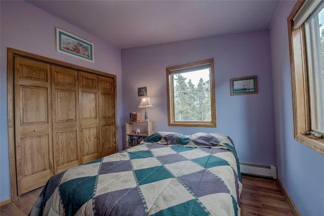 Bedroom with a baseboard radiator, wood finished floors, and a closet | Image 28