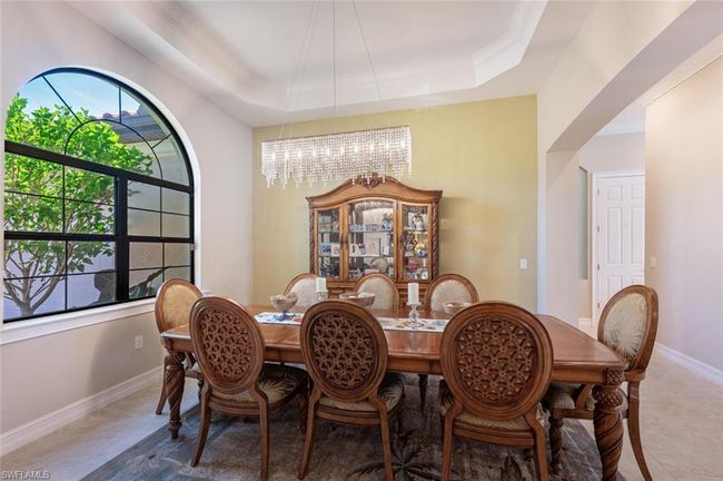 Dining room featuring a chandelier, a raised ceiling, ornamental molding, and baseboards | Image 12