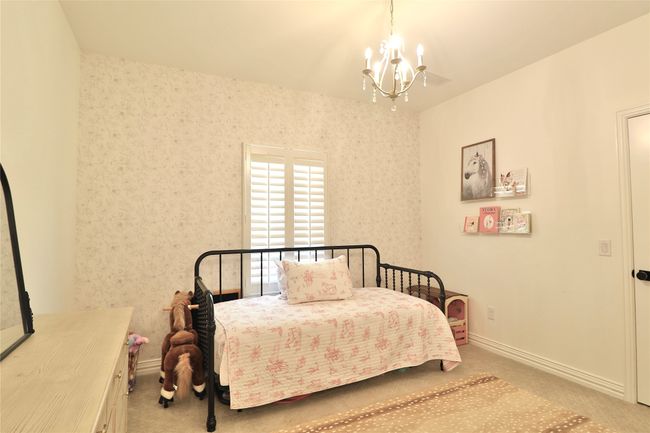 Bedroom with carpet flooring, baseboards, and an inviting chandelier | Image 15