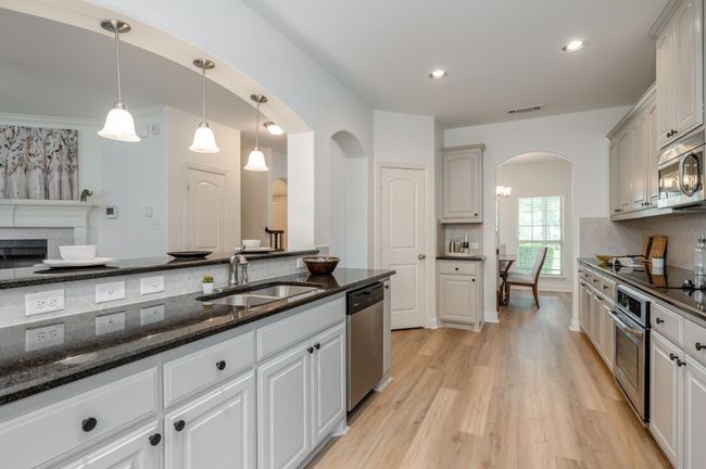 Kitchen featuring arched walkways, stainless steel appliances, light wood finished floors, tasteful backsplash, and recessed lighting | Image 9