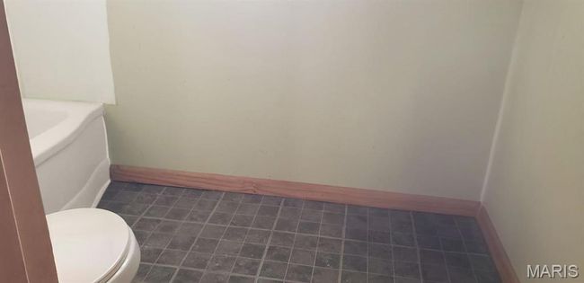 Bathroom featuring toilet, a tub to relax in, and baseboards | Image 8