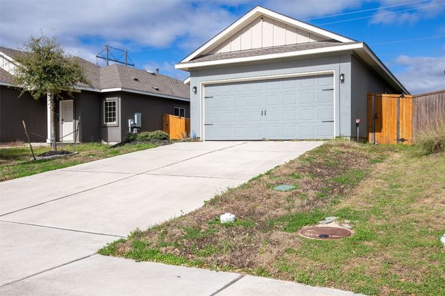 View of front of house featuring a gate, board and batten siding, a garage, and fence | Image 4