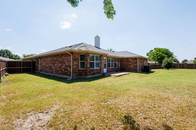 Back of property featuring a chimney, brick siding, central air condition unit, a patio, and roof with shingles | Image 29