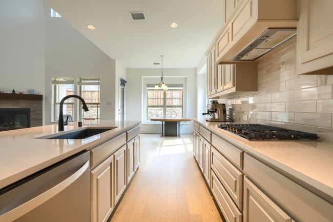 Kitchen featuring stainless steel appliances, a sink, visible vents, backsplash, and light countertops | Image 13