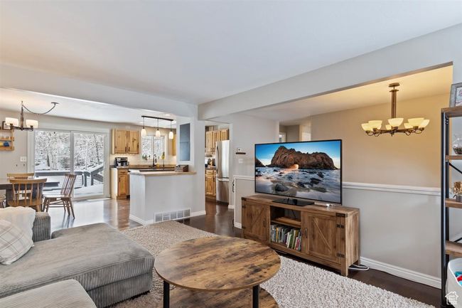 Living room featuring a chandelier, dark wood-style flooring, and baseboards | Image 11