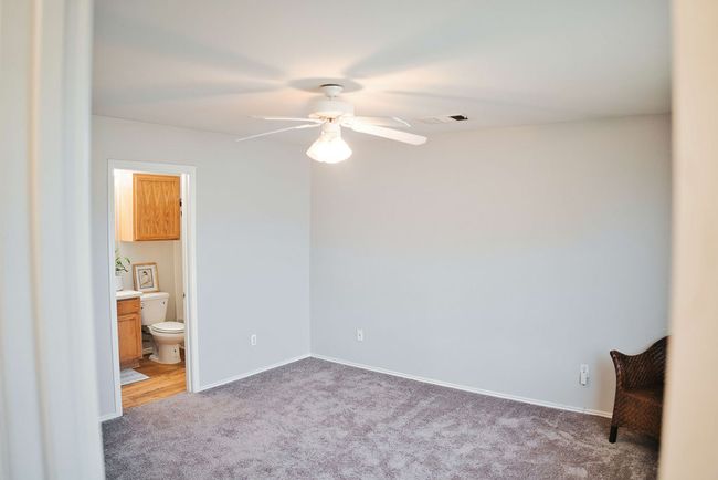 Unfurnished bedroom featuring carpet, ensuite bath, and ceiling fan | Image 19