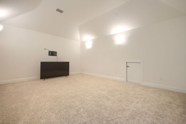 Basement featuring light carpet, baseboards, and visible vents | Image 25