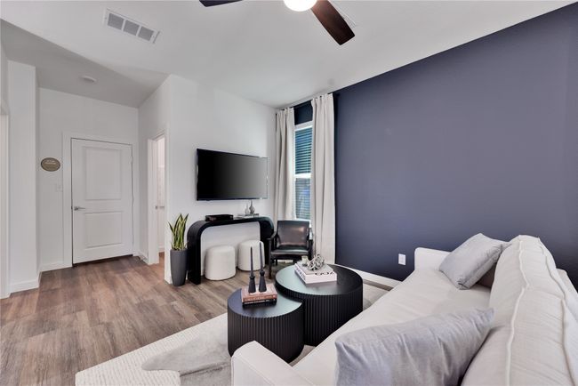 Living area featuring ceiling fan, wood finished floors, visible vents, and baseboards | Image 6