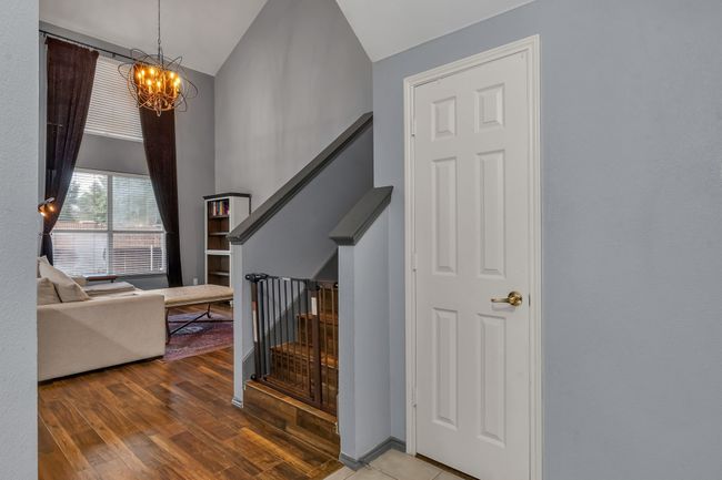 Staircase featuring a chandelier, wood finished floors, and high vaulted ceiling | Image 6