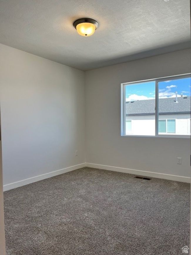 Empty room featuring a textured ceiling, carpet, baseboards, and visible vents | Image 13