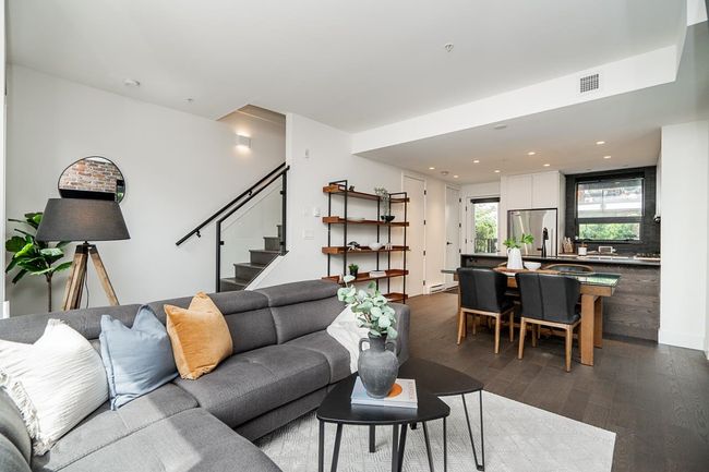 Living area with dark wood finished floors, recessed lighting, and stairway | Image 13