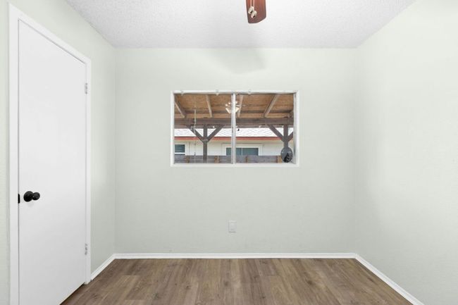 Empty room with dark wood-type flooring and a textured ceiling | Image 20