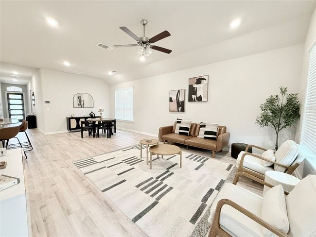 Living room featuring a ceiling fan, baseboards, a wealth of natural light, visible vents, and light wood-type flooring | Image 16