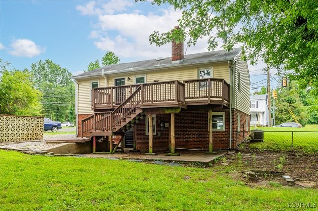 Rear view of house featuring a wooden deck, a chimney, stairway, and brick siding | Image 31