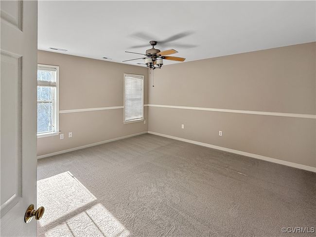 Carpeted empty room with a ceiling fan and baseboards | Image 12