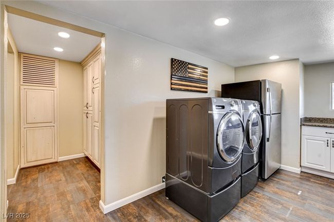 Laundry room featuring washing machine and dryer, dark wood finished floors, and recessed lighting | Image 31
