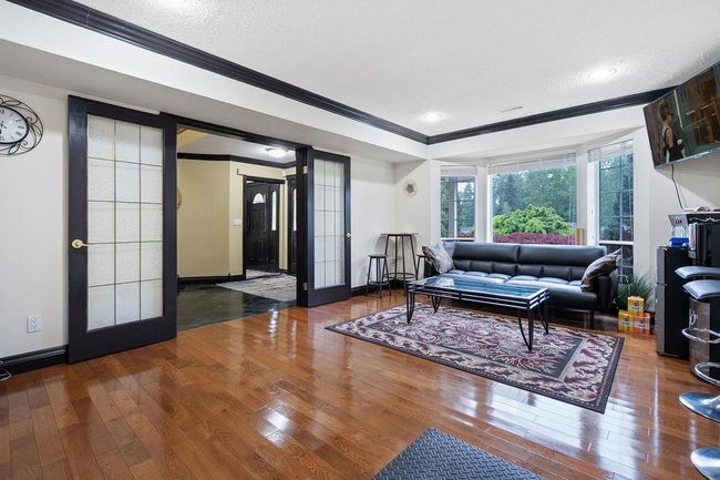 Living room featuring crown molding, hardwood / wood-style floors, baseboards, and a textured ceiling | Image 29