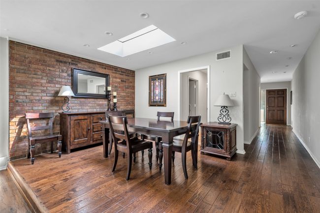 Open dining room with interior brick wall and skylight. Opens directly to the kitchen and living rooms - and is off the front hallway. | Image 11