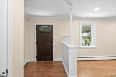 Entryway featuring ornamental molding, a baseboard heating unit, and hardwood / wood-style floors | Image 2