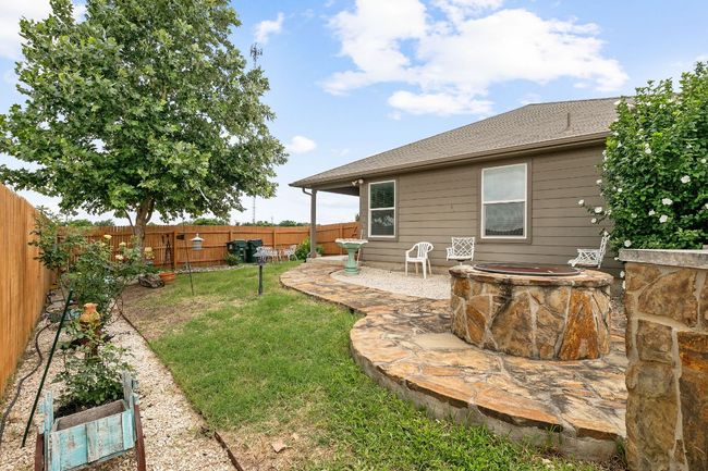 View of yard with an outdoor fire pit, a patio, and a fenced backyard | Image 15