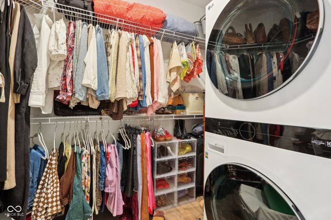 laundry room with stacked washer / dryer, laundry area, and wood finished floors | Image 31