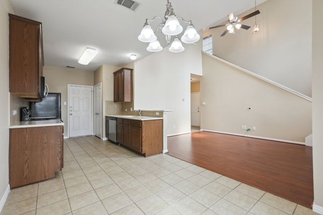 Kitchen with light tile patterned floors, appliances with stainless steel finishes, open floor plan, and light countertops | Image 12