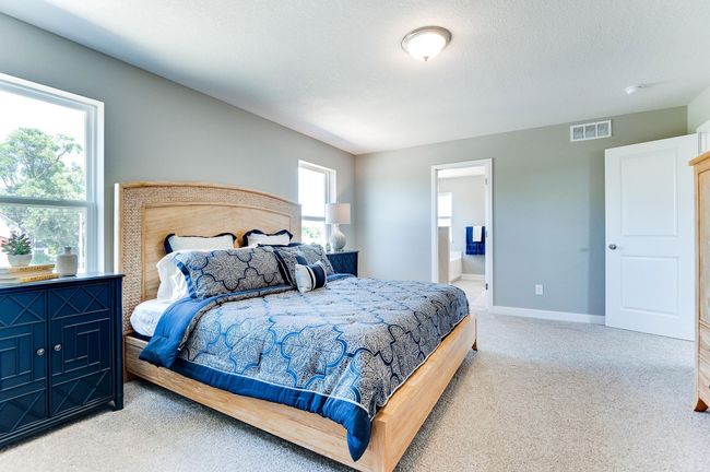 A second view of the Primary Suite. Shown here with a King-sized bed, the room is overly spacious and offers the perfect setting to start and finish each day in! Photo of model home, color and options will vary. | Image 26